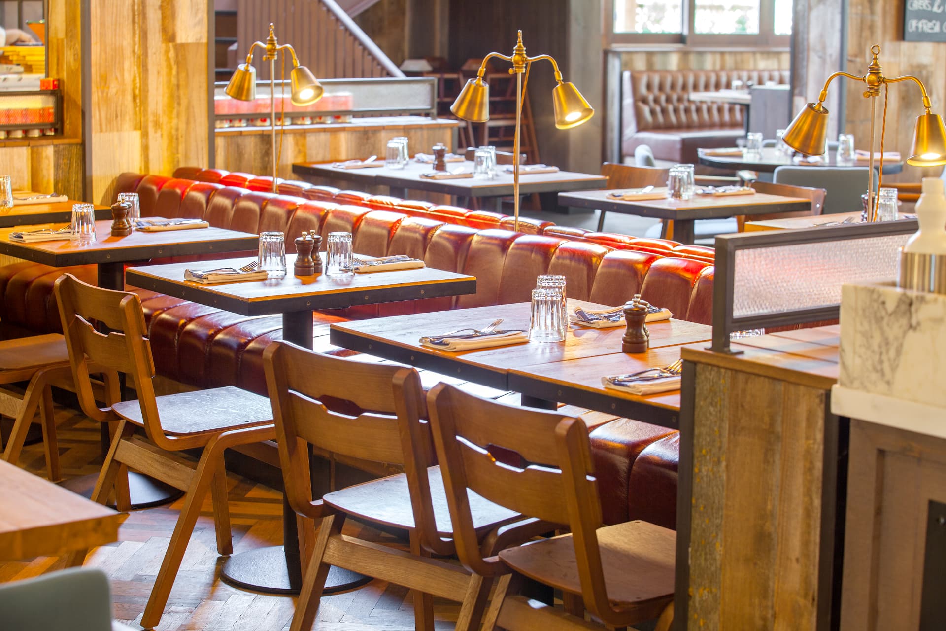 Banquette seating with brass table lamps and marble detailing