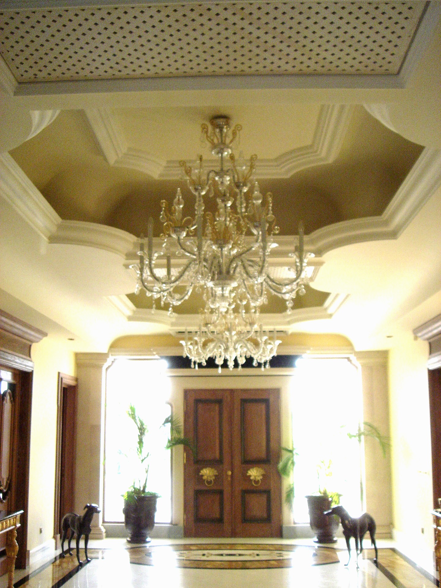 Entrance vestibule with coffered ceiling and Murano glass chandelier above the panelled front doors