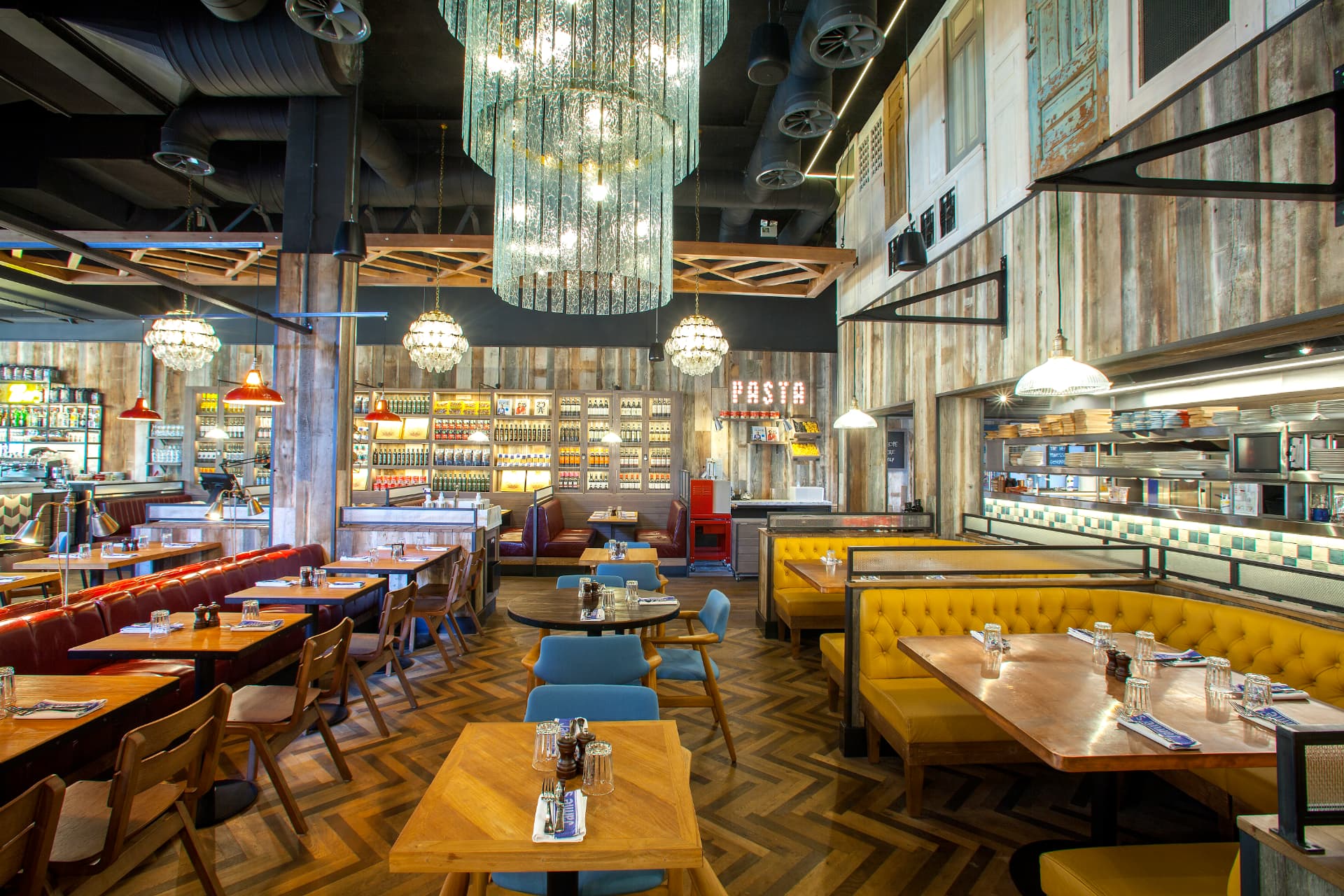 Herringbone floors, tufted banquettes and layered decorative lighting