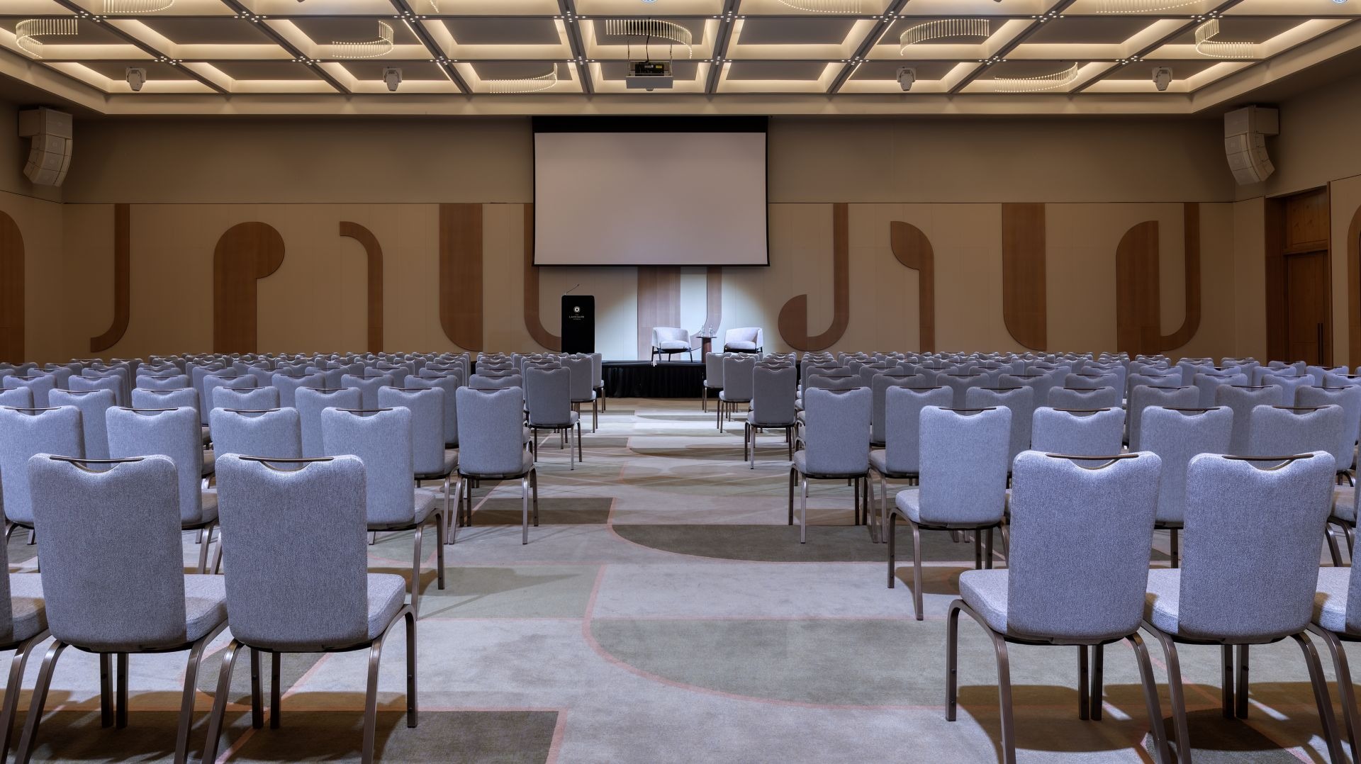 Wide view of the ballroom in theatre layout with sculpted timber wall panelling